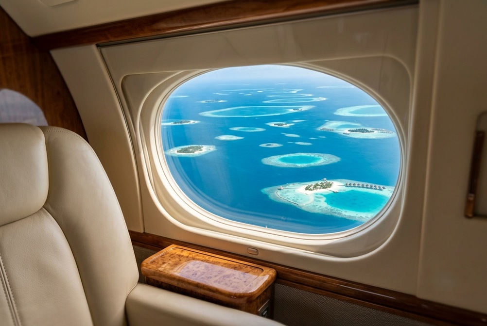 view of the Maldivian atolls from a private jet window